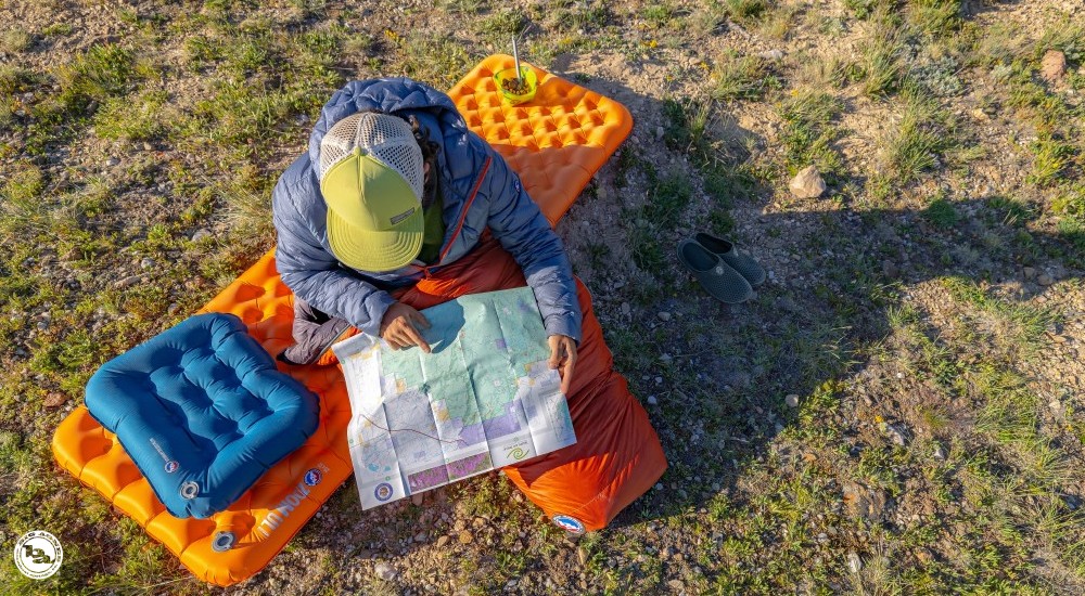 a person looking at the map while in their sleeping bag
