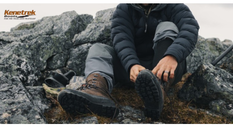man wearing kenetrek boots lacing them on a mountain