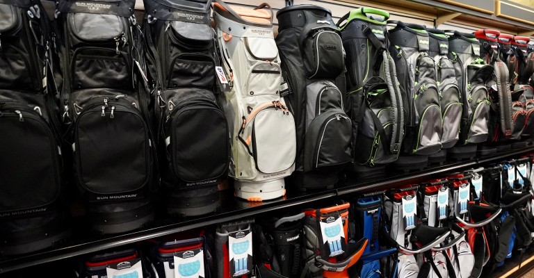 a variety of golf bags at a scheels golf shop