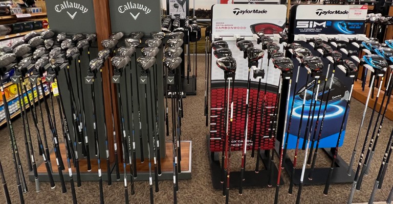 a variety of golf clubs at a scheels golf shop