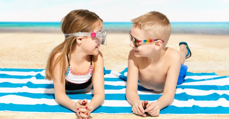 Two kids laying on the beach