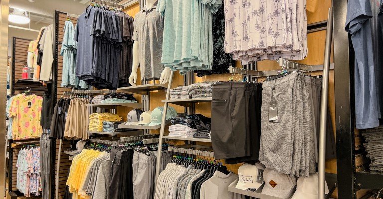 a variety of golf clothing on display at a scheels golf shop