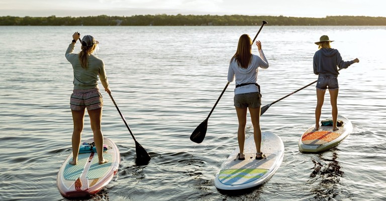 riding paddle boards on a lake