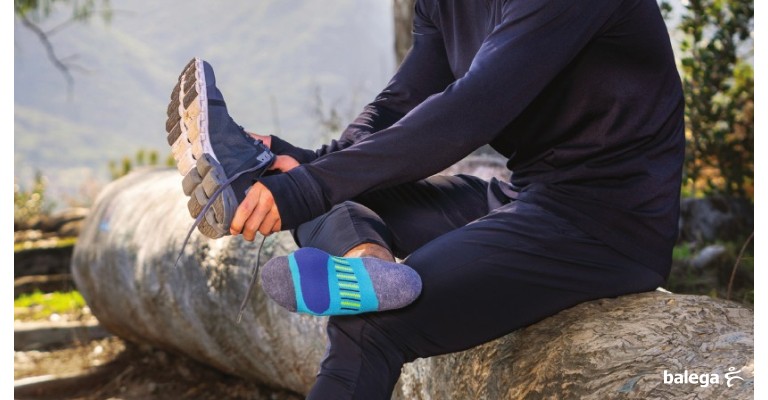 a man putting on a pair of running socks