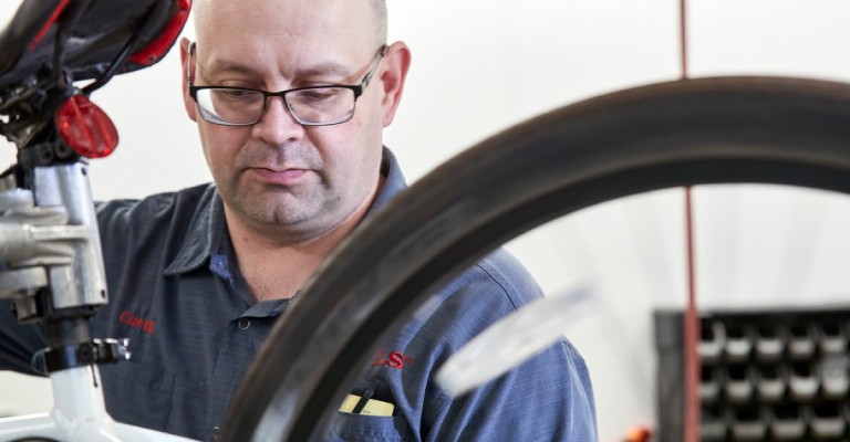 SCHEELS service shop associate working on a bike