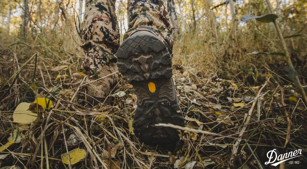 a hunter walking through the woods in fall