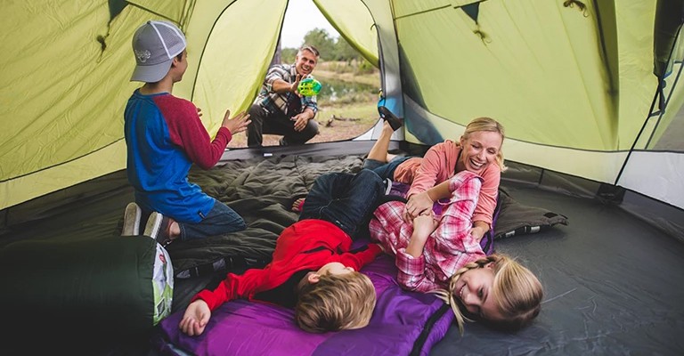 A family getting the inside of their tent ready