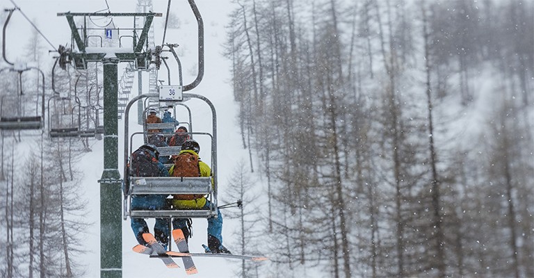 skiers and snowboarders on a ski lift