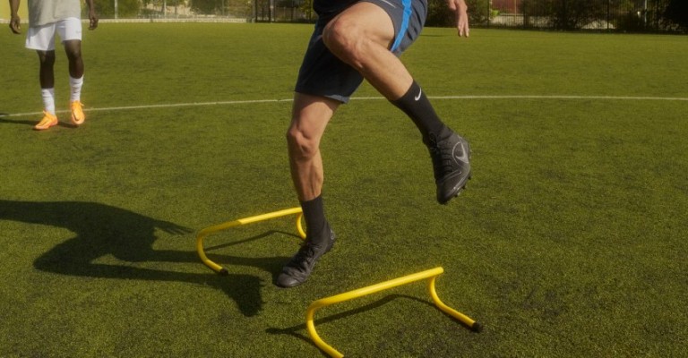 Athletes doing agility drills with mini hurdles