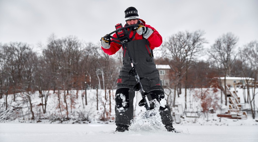 a person using an ice auger out ice fishing