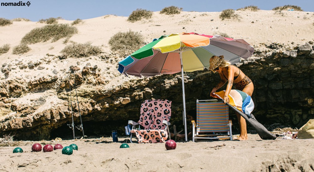 a woman setting up her stuff on the beach