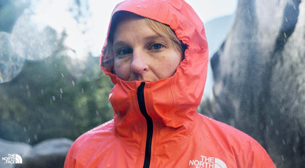 a woman wearing a rain jacket when rock climbing