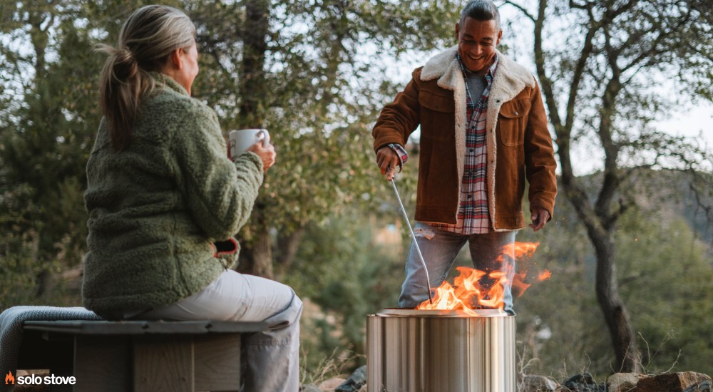 people sitting around a solo stove bonfire outside