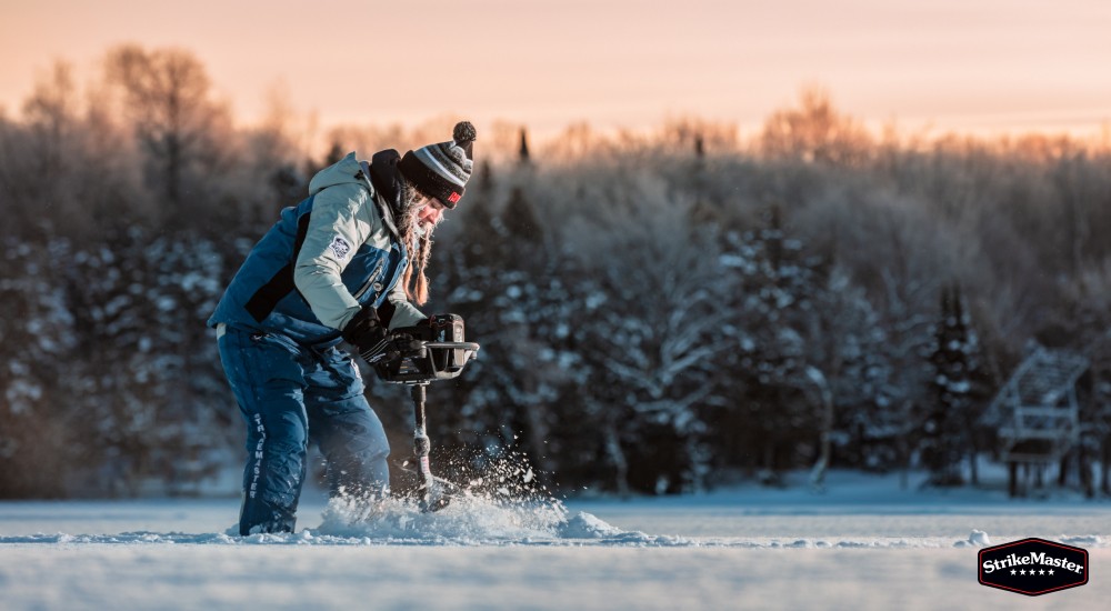 woman ice fishing on lake wearing striker bibs
