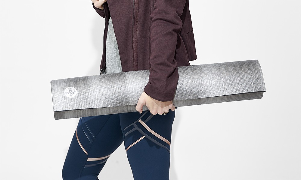 A yoga person carrying a yoga mat